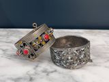 a pair of silver bracelets with red and yellow stones