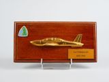 plaque en bois sur laquelle figure un avion doré sur fond blanc