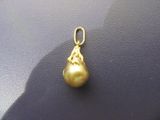 pendentif en perle jaune sur un fond noir, avec une ombre derrière