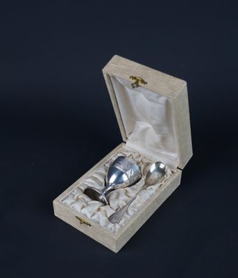 a silver spoon in a wooden box on a black background