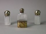 three small glass bottles with gold caps and a small glass bottle with a gold top