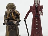 two figurines of a man and a woman standing next to each other