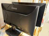 a computer monitor sitting on top of a wooden desk