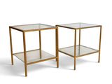 a pair of glass and brass side tables