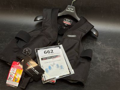 un gilet noir et quelques autres objets posés sur une table