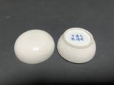 pair of white porcelain vases with chinese writing on them on a black surface