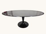 une table ronde en verre avec un piètement noir