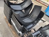a lot of black plastic seats on a pallet