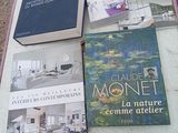 une valise rose posée par terre, sur laquelle sont posés des livres