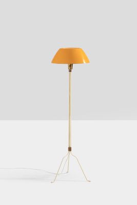 a yellow floor lamp on a white surface with a white background