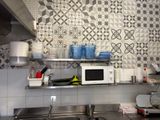 a kitchen with a microwave, sink, and a lot of dishes on the counter