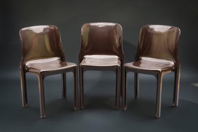 trois chaises placées côte à côte dans une pièce sombre