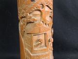 a wooden vase with carvings on it on a black background