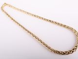 a gold plated necklace with a braid design on a white background