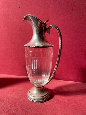 un pichet ancien en verre plaqué argent sur fond rouge