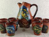 six cups and a pitcher sitting on a table