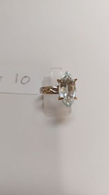 a close up of a gold ring with a blue topaz stone