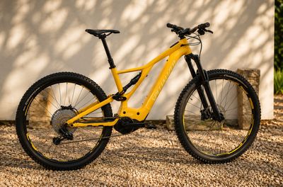 une photo d'un VTT jaune garé devant un mur blanc