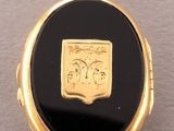 a close up of a gold locke with a black stone in it