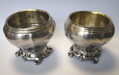 paire de bols anciens en métal argenté sur socles, sur fond blanc