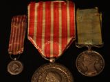 trois médailles et une médaille posée sur un fond noir