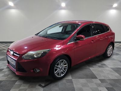 Une Ford Focus rouge est garée dans une pièce dont le sol est en damier.