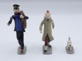 trois figurines représentant un homme, une femme et un chien