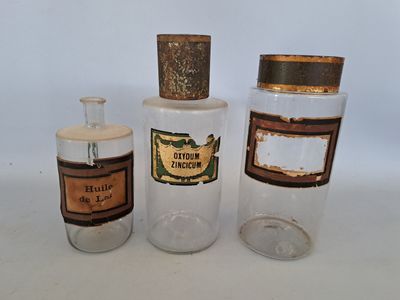 trois bouteilles différentes, munies d'étiquettes, posées sur une table