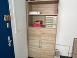 a cabinet with a door and a microwave on top of it