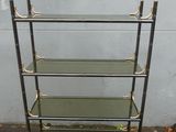 a metal and glass shelf with four shelves on top of it