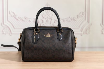 a coach purse sitting on top of a wooden table