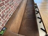 un banc en bois situé près d'un mur en briques