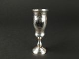 un gobelet en argent posé sur une table noire
