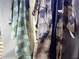 trois kimonos suspendus à un portant devant un fond blanc