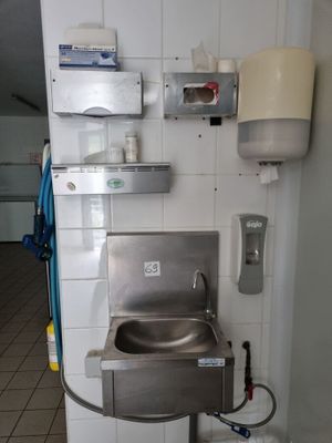 un évier en acier inoxydable dans le coin d'une salle de bains