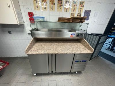 un comptoir sur lequel sont posées plusieurs pizzas