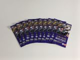un lot de six paquets de cartes à collectionner Pokémon posés sur une surface blanche