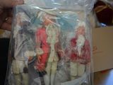 a person holding a bag of dolls in front of a box of other dolls