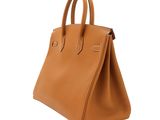 a brown leather handbag on a white background