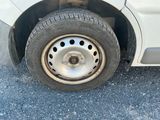 une voiture blanche avec un pneu crevé dans la rue