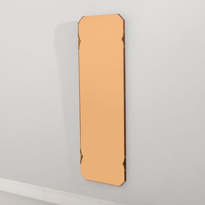 un miroir accroché au mur dans une pièce aux murs blancs