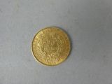 a gold coin that is on a white surface