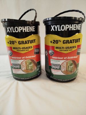 two buckets of paint sitting on top of a bed