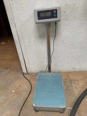 une balance posée par terre à côté d'un tuyau d'arrosage