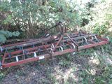 a tractor plow that is laying in the grass