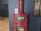a red stove sitting on a wooden floor in a room