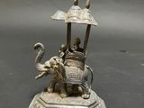 statue of a man riding an elephant with a man on top of it