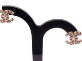 une paire de boucles d'oreilles posée sur un présentoir noir