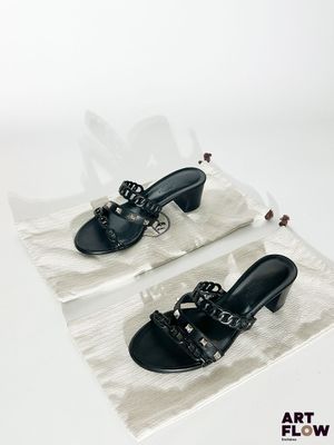 deux paires de chaussures noires posées sur un sac en plastique