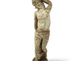 une vieille statue représentant un homme, les mains sur la tête